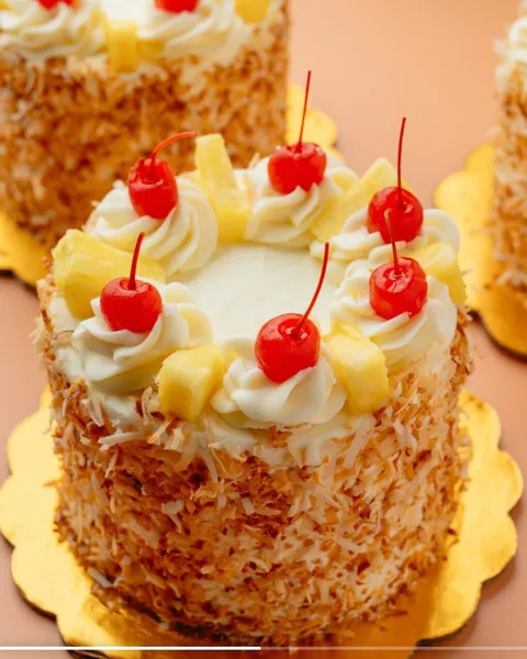 Piña Colada Cake de SOAD Bakery con coco tostado y cerezas